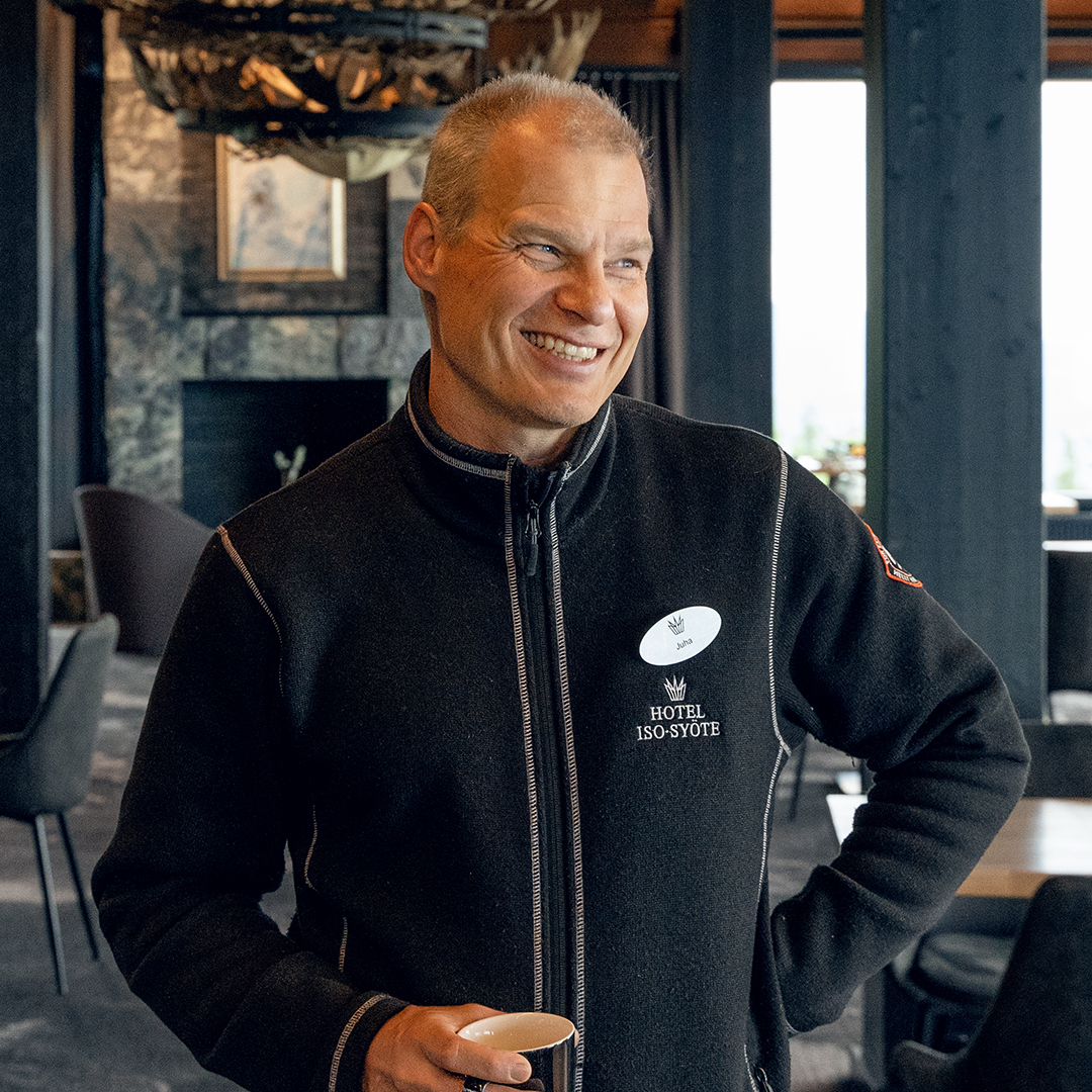 A smiling man standing in a hotel restaurant.