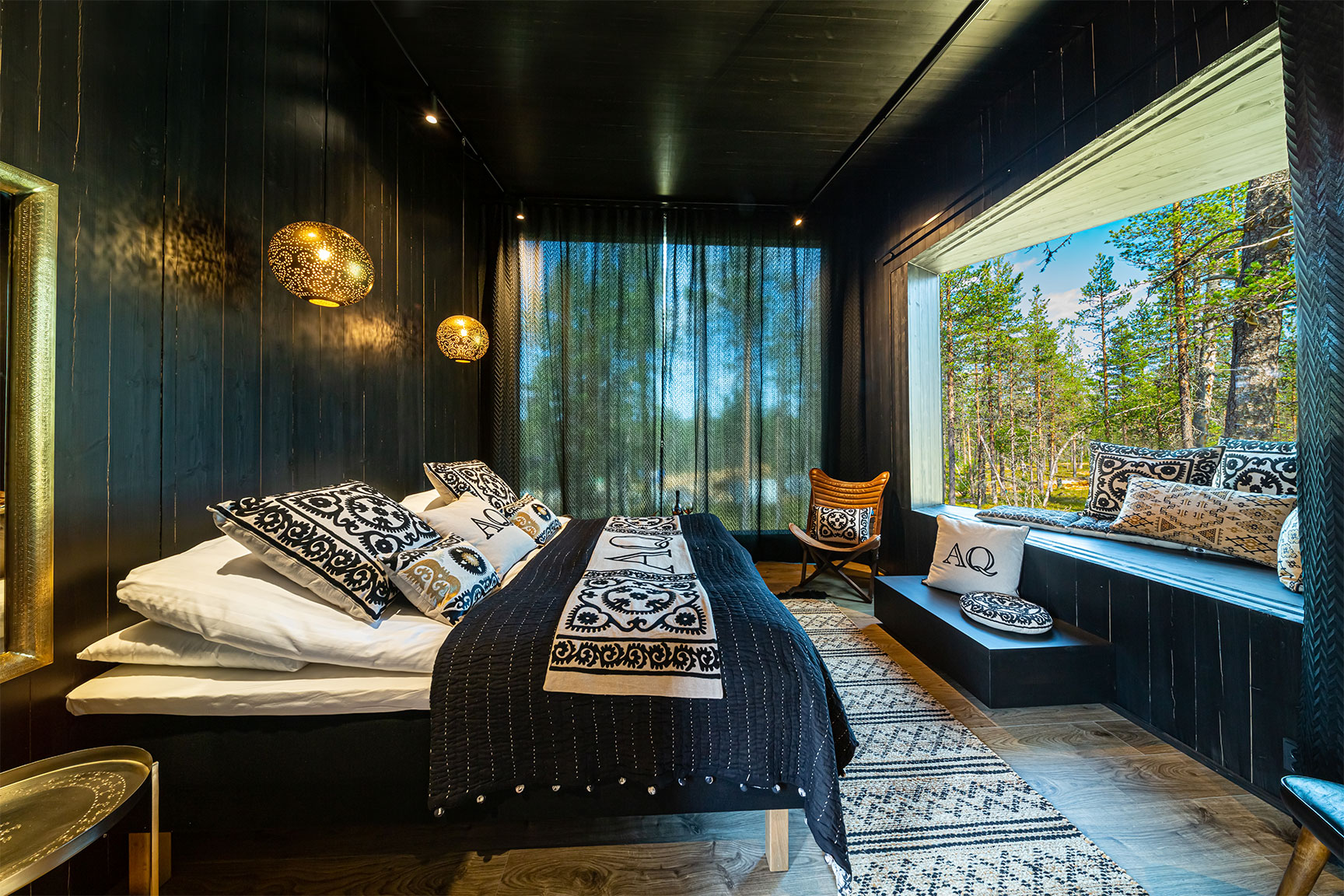 A wooden rustic design room in a resort in the middle of a summery forest in Finnish Lapland.